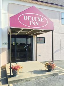 un cartello di declino della locanda di fronte a un edificio di Deluxe Inn a West Memphis