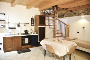 a kitchen and dining room with a table and a kitchen and stairs at A casa di Sole Brovello in Brovello-Carpugnino