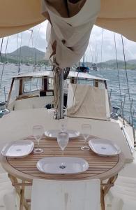 a table with glasses and plates on a boat at Voilier CHENRESIK in Le Marin