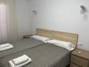 1 dormitorio con 1 cama con 2 almohadas blancas en VILLA MAR, en Cala'n Bosch