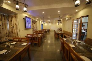 un restaurante con mesas de madera y sillas en una habitación en The Kumbha Mahal Resort, en Kumbhalgarh