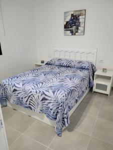 a bed with a blue and white comforter in a bedroom at Apartamento Roque Las Campanas in Tamaduste
