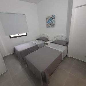 a room with two beds and a window at Apartamento Roque Las Campanas in Tamaduste