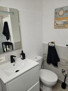 a bathroom with a white toilet and a sink at Apartamento Roque Las Campanas in Tamaduste