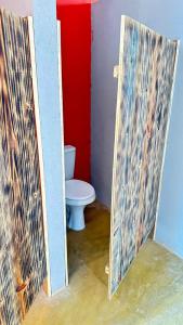a bathroom with a toilet and a red wall at A Chave da Montanha 