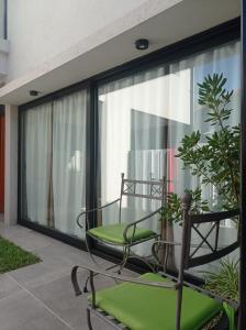 een balkon met een glazen tafel en stoelen voor een raam bij La Vasca in Manuel B. Gonnet