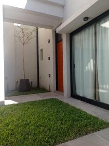 una casa con un prato verde davanti ad una porta di La Vasca a Manuel B. Gonnet
