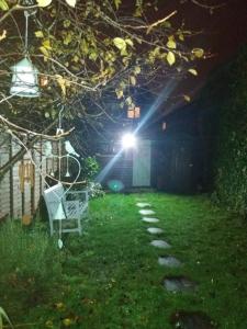 a light shining in a yard at night at Cosy London single room (near Wimbledon) in London