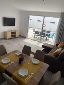 a living room with a table and a couch at Vuelo, Villa con piscina y barbacoa para disfrutar in Puerto Calero