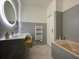 a bathroom with a sink and a tub and a mirror at Le P’tit B - Quartier Saint-Michel/Centre Ville in Saint-Brieuc