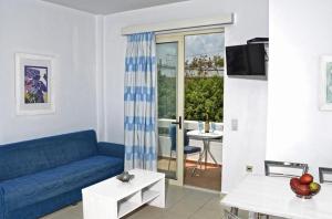 a living room with a blue couch and a table at Oliv Apartments in Platanes