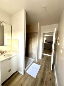 Cosy appartement centre Cusset في Cusset: حمام أبيض مع حوض ومرآة