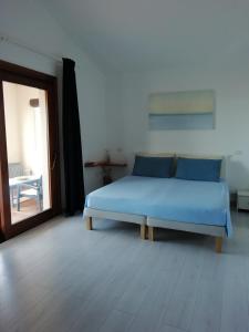 een slaapkamer met een blauw bed in een kamer bij Frina di Mari b&b in San Teodoro