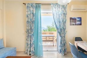 a room with a window with blue curtains at Nice seaview balcony Porlamar Home 155 in Glyfada