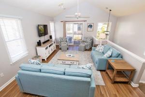 ein Wohnzimmer mit 2 blauen Sofas und einem Tisch in der Unterkunft M24, Sunshine and Tan Lines- Oceanside, Community Pools in Corolla