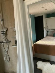 a bathroom with a bed and a shower in a room at Spiced Bed&Breakfast in Nykøbing Falster