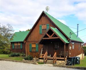 un grande fienile in legno con tetto verde di Bridgeview Lodge a Whitney