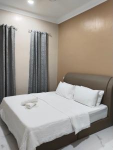 Villa Adeeva Homestay Langkawi في بانتايْ سينانج: سرير بشرشف ووسائد بيضاء في الغرفة