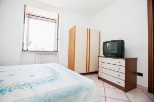 ein Schlafzimmer mit einem Bett und einem TV auf einer Kommode in der Unterkunft Casa Ferrigno in Maiori