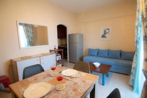 a living room with a table and a blue couch at Nice seaview balcony Porlamar Home 155 in Glyfada