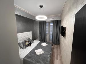 a bedroom with a bed with a black comforter at Apartments Lux Palas in Iaşi