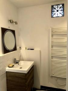 a bathroom with a sink and a mirror at maison de ville agréable La roseraie Musicale in Mer