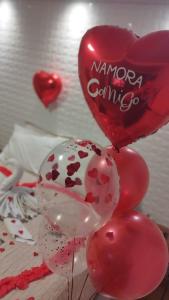a bunch of red and white balloons in a bedroom at Pousada Bella Vista - Vale dos Vinhedos in Bento Gonçalves