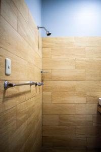 y baño con ducha y pared de madera. en Hospedaje Tel Aviv, en Ayacucho