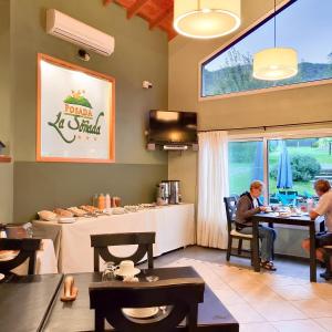 a person sitting at a table in a restaurant at Posada La Soñada in Villa General Belgrano