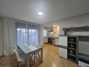 - une cuisine et une salle à manger avec une table et des chaises dans l'établissement Apartamento Nara Playa, à Boiro