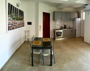 a kitchen and dining room with a table and chairs at Residencial Ilha do Maio App 101 in Santa Maria