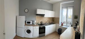a kitchen with a white refrigerator and a washing machine at Appartement logis balnéen in Bains-les-Bains