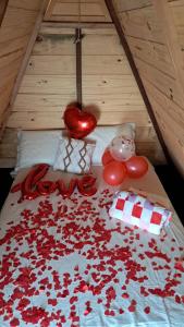 a bed with red rose petals on it at A Chave da Montanha 