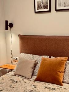 a bedroom with a bed with two pillows and a table at Katrina - Kunigiškių apartamentai - Mano Jūra 2 in Palanga