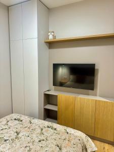 a bedroom with a bed and a tv on a wall at Katrina - Kunigiškių apartamentai - Mano Jūra 2 in Palanga