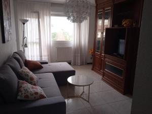 a living room with a couch and a tv at Mar de Gala in Suances