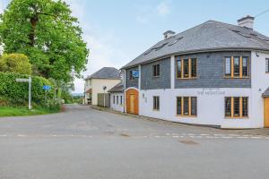 a white building with a gray roof on a street at Olive Tree Cottage in Exeter