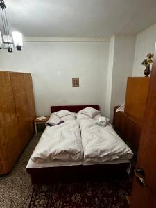 a bedroom with a bed with white sheets at Ubytovanie u Babičky in Martin