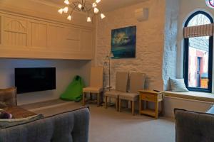 a living room with chairs and a flat screen tv at Newton Hall in Inveraray