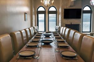 a long table in a room with chairs and a large table at Newton Hall in Inveraray