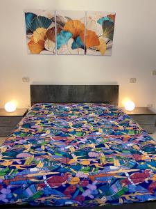 a bed with a colorful blanket on top of it at il Nido sul lago Trasimeno in Castiglione del Lago