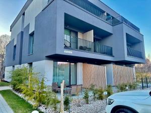 a building with a car parked in front of it at Katrina - Kunigiškių apartamentai - Mano Jūra 2 in Palanga
