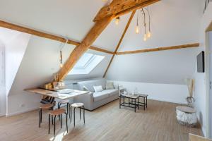 an attic living room with a couch and a table at T2 cosy et chic près de la Défense et de Paris in Maisons-Laffitte