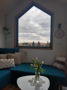 a living room with a blue couch and a window at Natura Tiny House in Mărişel