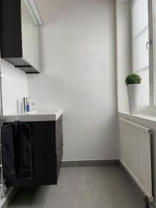 a white bathroom with a sink and a window at Timrå Farmhouse in Timrå