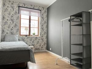 a bedroom with a bed and a book shelf at Timrå Farmhouse in Timrå