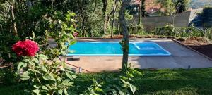 PiranguinhoEcoHousing Gaia Terranova Hospedagem eco pet friendly的一座游泳池,位于一个粉红色玫瑰的院子内