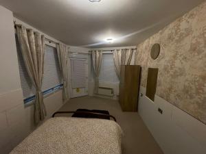 a bedroom with a bed and two windows at Beanie’s @LorneStreet in Swindon