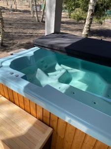 a large hot tub in a wooden deck with at Domki Plaża Kownatki VIP in Kozłowo