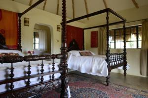 a bedroom with two beds with white sheets at Olepangi Farm in Nanyuki